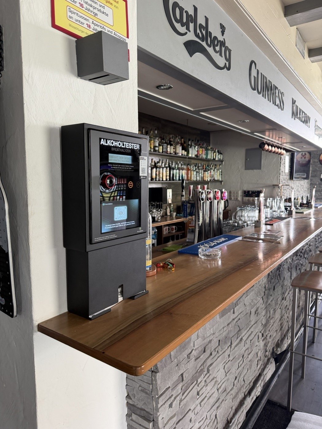 PromilleBox wandmontiert an der Bar im s'Pub in Wolfhausen, betriebsbereit neben den Zapfhähnen